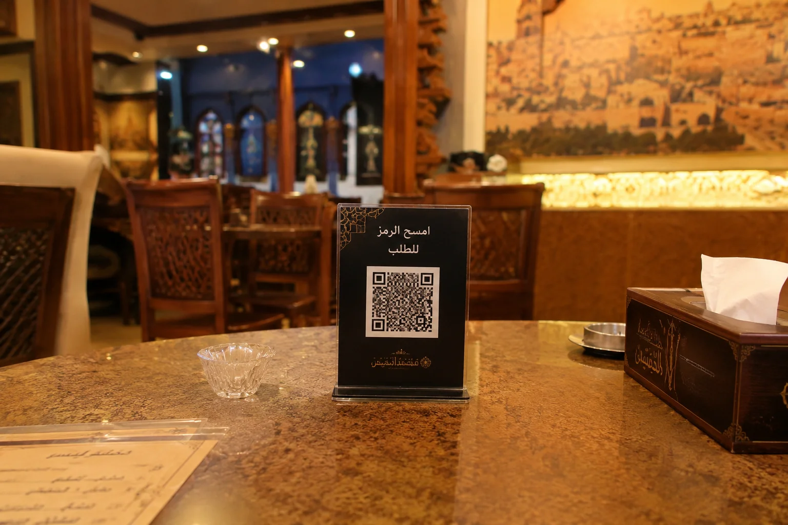 ستاند رمز QR على طاولة مطعم مكتوب عليه امسح الرمز للطلب